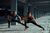 Two people stretching in a side lunge position 