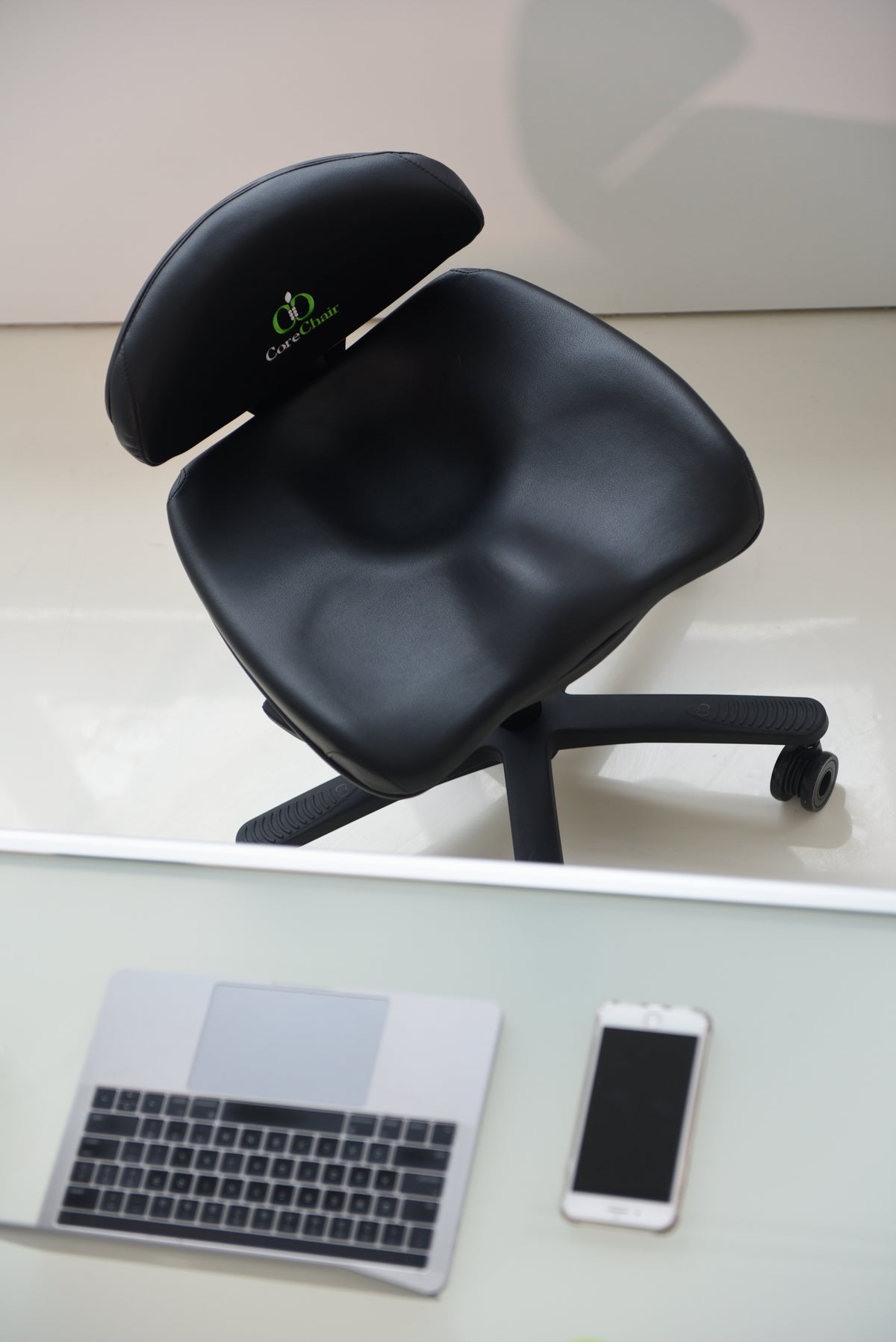 Ergonomic CoreChair Sport with lumbar and pelvic support, leather-look finish, and pivot base for active sitting in a modern office.


