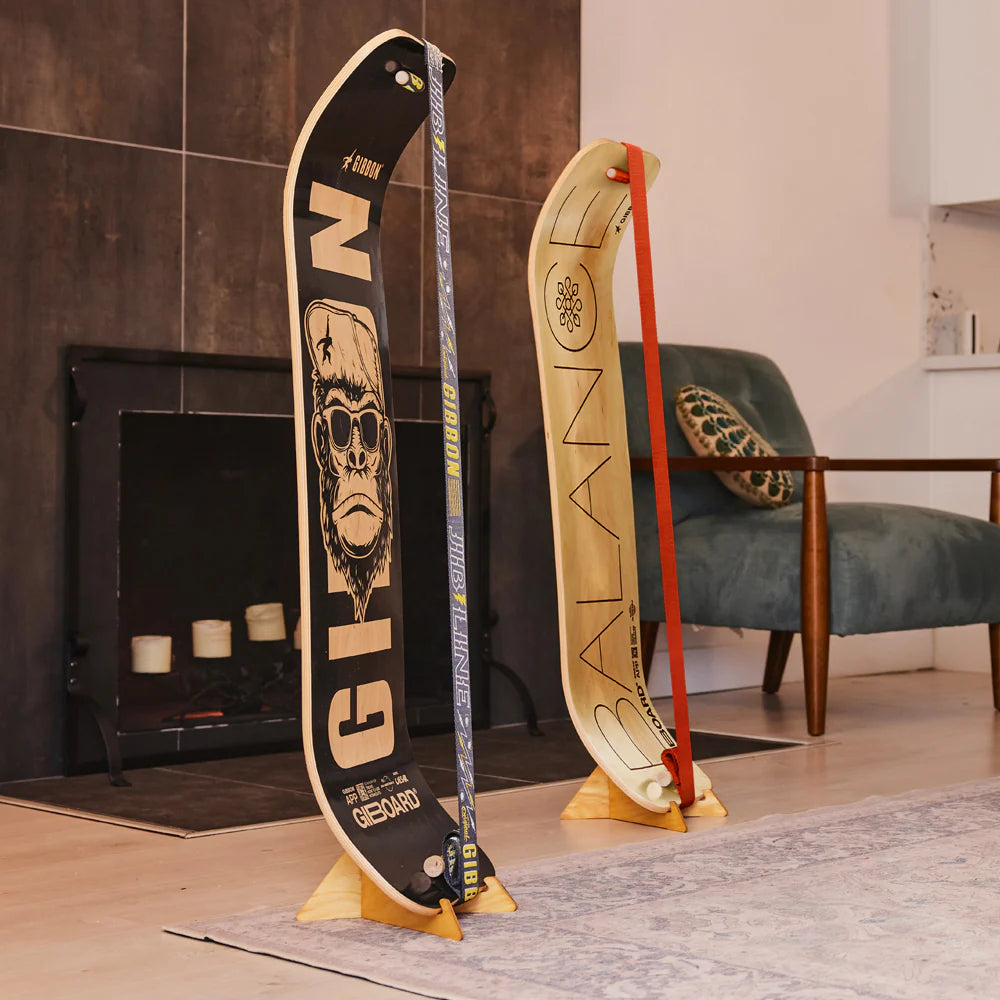Two Gibbon SlackBoards stored upright on stands in a living room, SlackBoard Stands ships from Canada