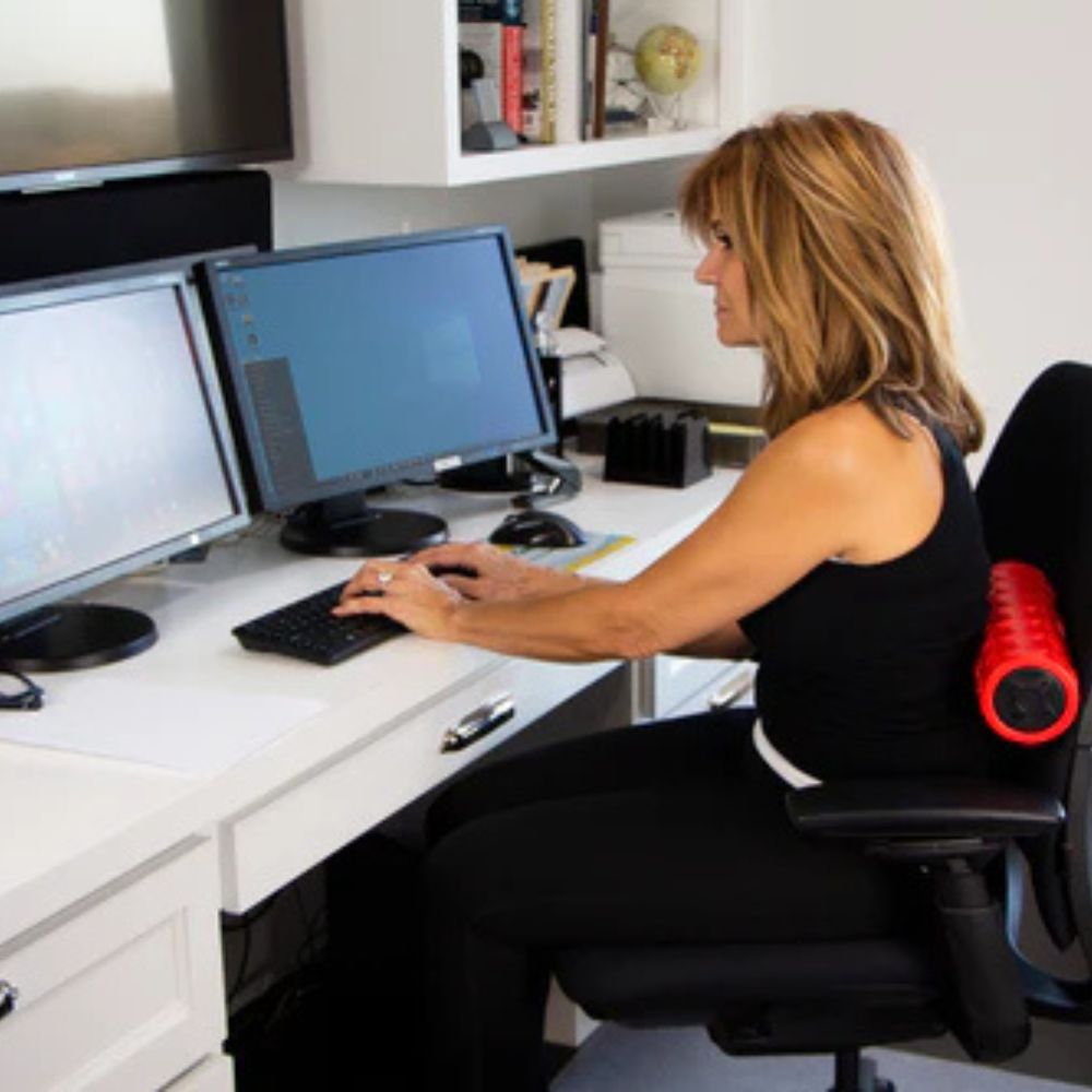Power Plate vibrating foam roller in use while sitting at a desk, ships from Canada