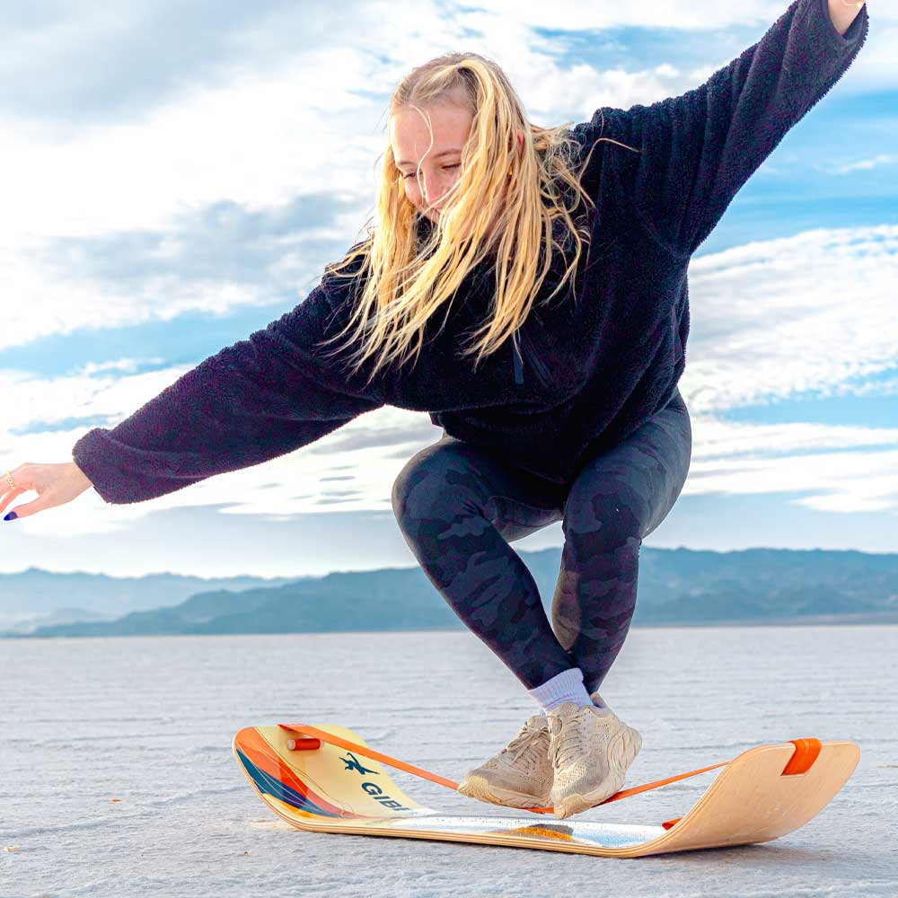 Person training on the GIBBON SlackBoard Pro, a low-profile wooden balance trainer for athletes and rehab