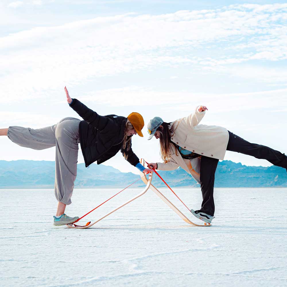 Pair of women demonstrating the slackline balance trainer loved by outdoor enthusiasts for single leg balance traning