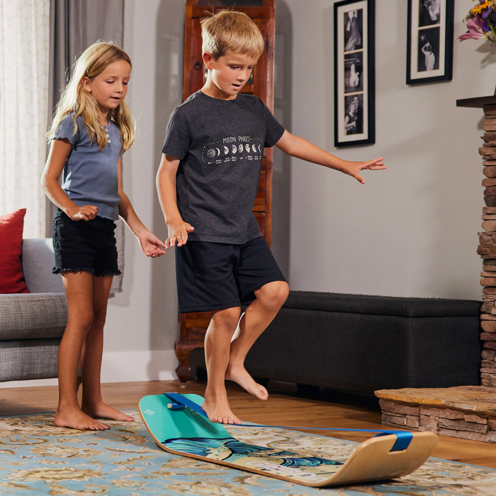 Kids using slackline balance trainer indoors, with a low-profile safe design to challenge their balance