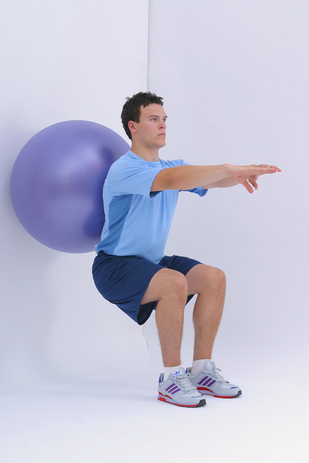 Wall sit with exercise ball at back