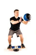 Challenging balance board for athletes, balancing while using a medicine ball
