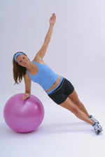 woman in exercise gear doing a single arm  plank balance on an exercise ball